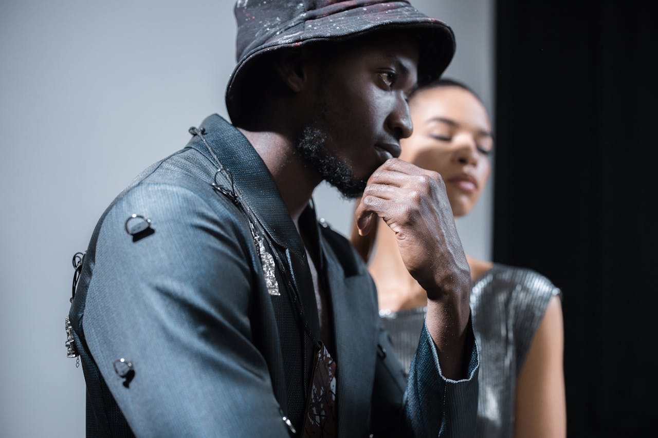 Stylish African American man posing with thoughtful expression in a studio setting.